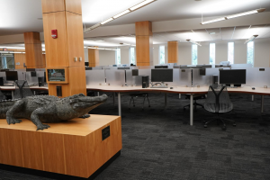 An alligator statue and computer desk area in Library West.