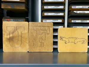 Wooden blocks used for die cutting paper into shapes. These shapes are the letters U and F, as well as an alligator.