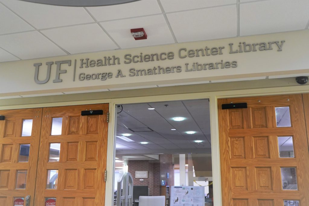 Wooden entrance doors with the sign Health Science Center Library