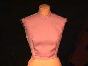 This mannequin is wearing a bodice with darts extending from the bust apex to the waist.