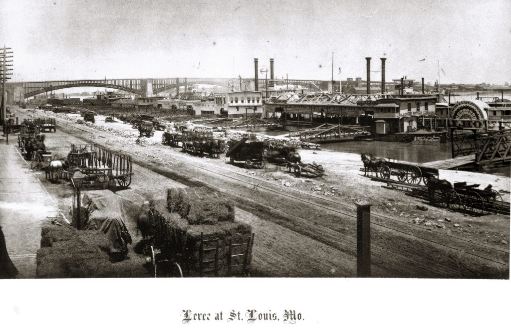 A levee and bridges over a river. There are carts and wagons on the land in the foreground. Words at the bottom read "Levee at St. Louis, Mo."