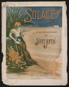 Sheet music cover, with the title "Solace" in large lettering at the top. The entire page is filled with a colored illustration of two women in a desert, one kneeling and leaning against the other one, next to a tree and vase of flowers. Across the sand in the distance is a building. Words in the middle of the page read "A Mexican Serenade by Scott Joplin." A stamped logo for Seminary Music Co. is at the bottom right, the words inscribed on a ribbon surrounded by two cherubs.