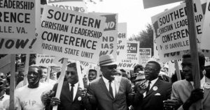 A crowd of people holding demonstration signs, reading "Southern Christian Leadership Conference, Virginia State Unit."