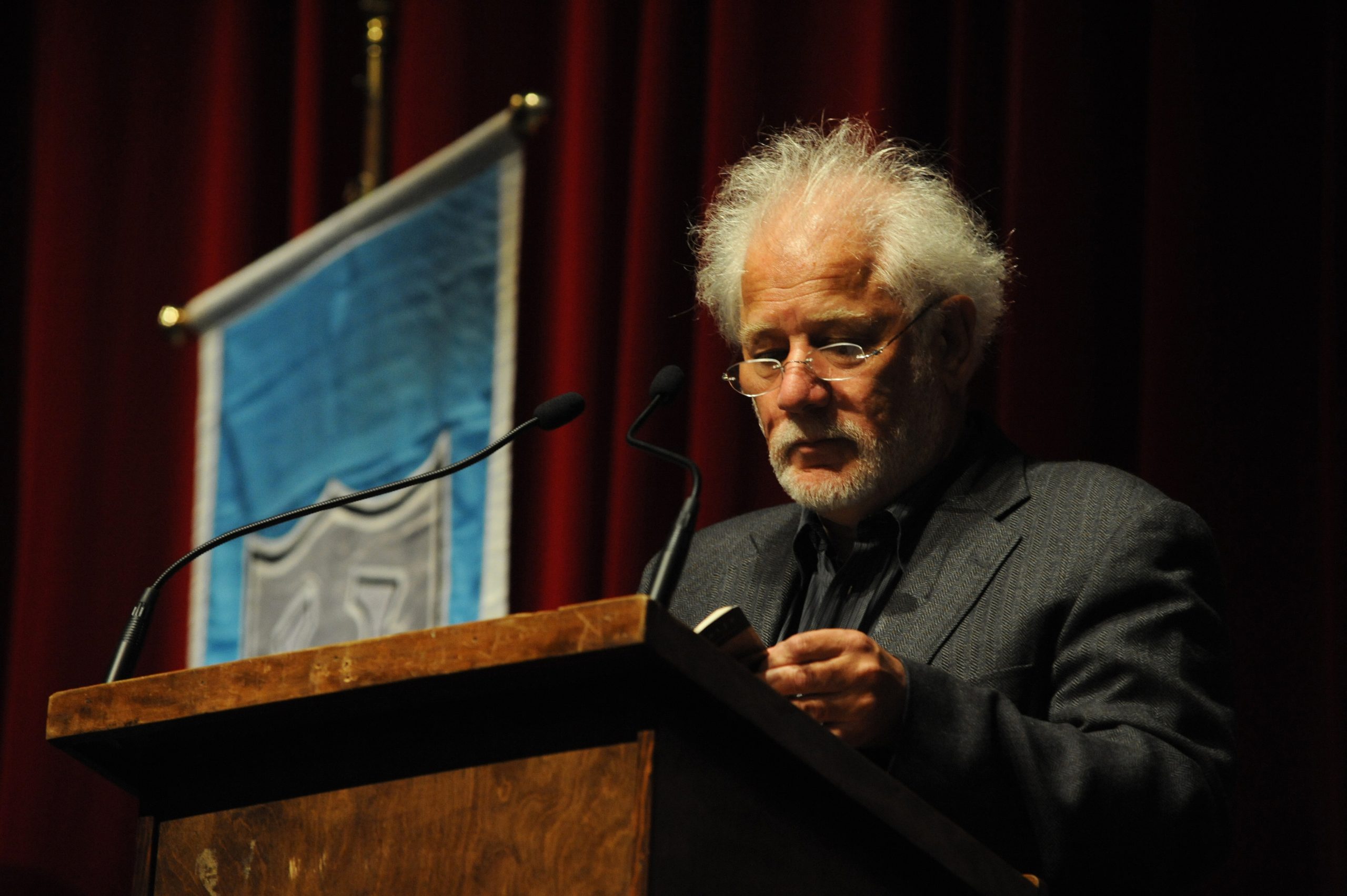 Man speaking at lecture with a microphone