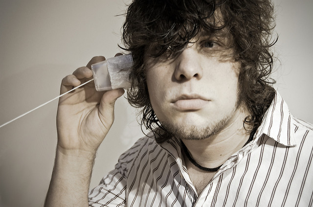 A man using a string telephone