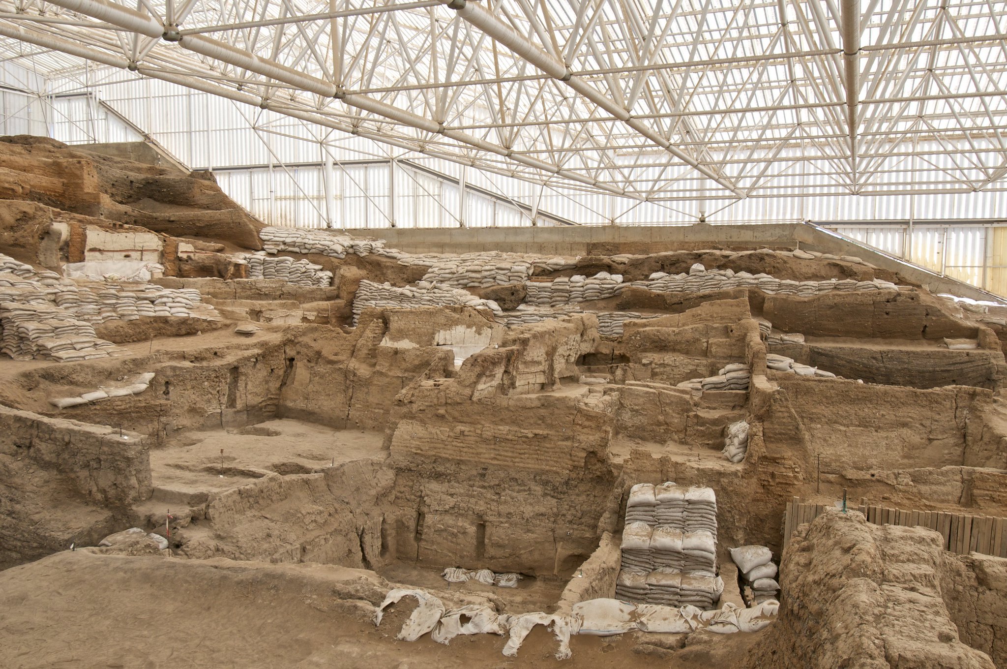 Excavation area, mainly beige bricks, with roof-scaffolding overhead