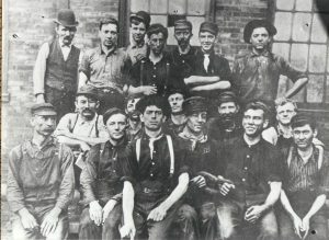 Steelworkers posing for photo in three levels