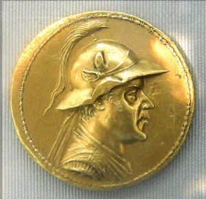 Gold coin with man's side profile face waring a hat