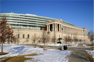 Exterior image of large building constructed of glass and concrete. Snow in foreground.