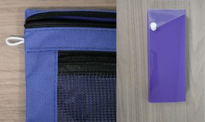 Blue canvas pencil case next to a purple hardshell pencil case