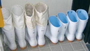 Two pairs of calf-high white rubber boots and two pairs with fabric toppers to the knee
