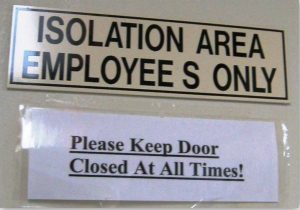 Sign on the entrance door into an isolation room that states “Isolation Area, Employees Only, Please Keep Door Closed at All Times”.