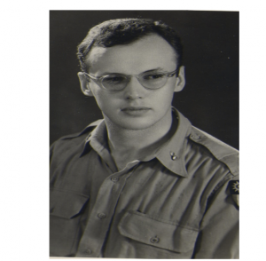 Black and white photograph of John, who is looking straight past the camera with a serious expression.