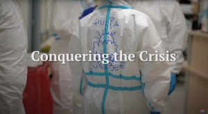 Healthcare worker facing away from the camera with the text "Conquering the Crisis"